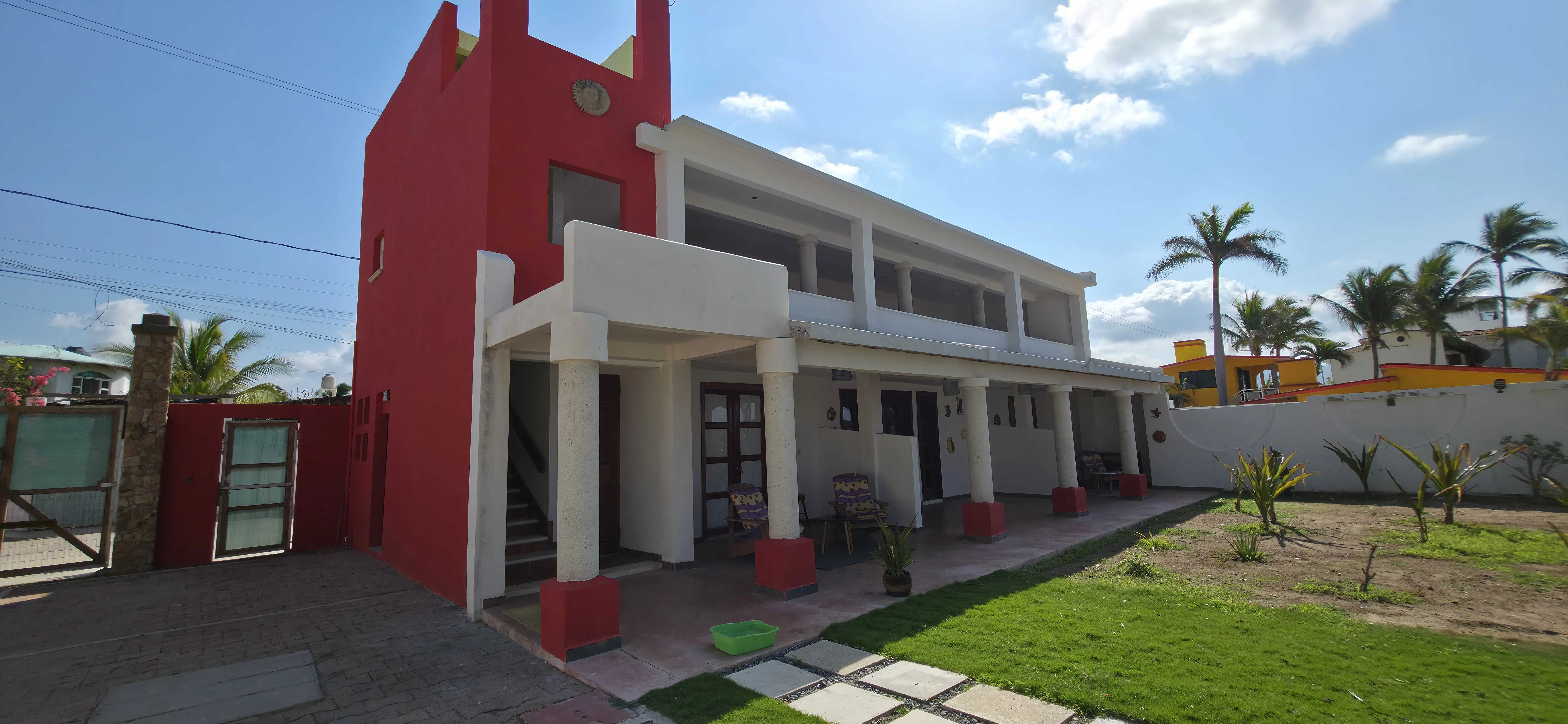 Fachada principal de la villa de dos pisos en rojo y blanco