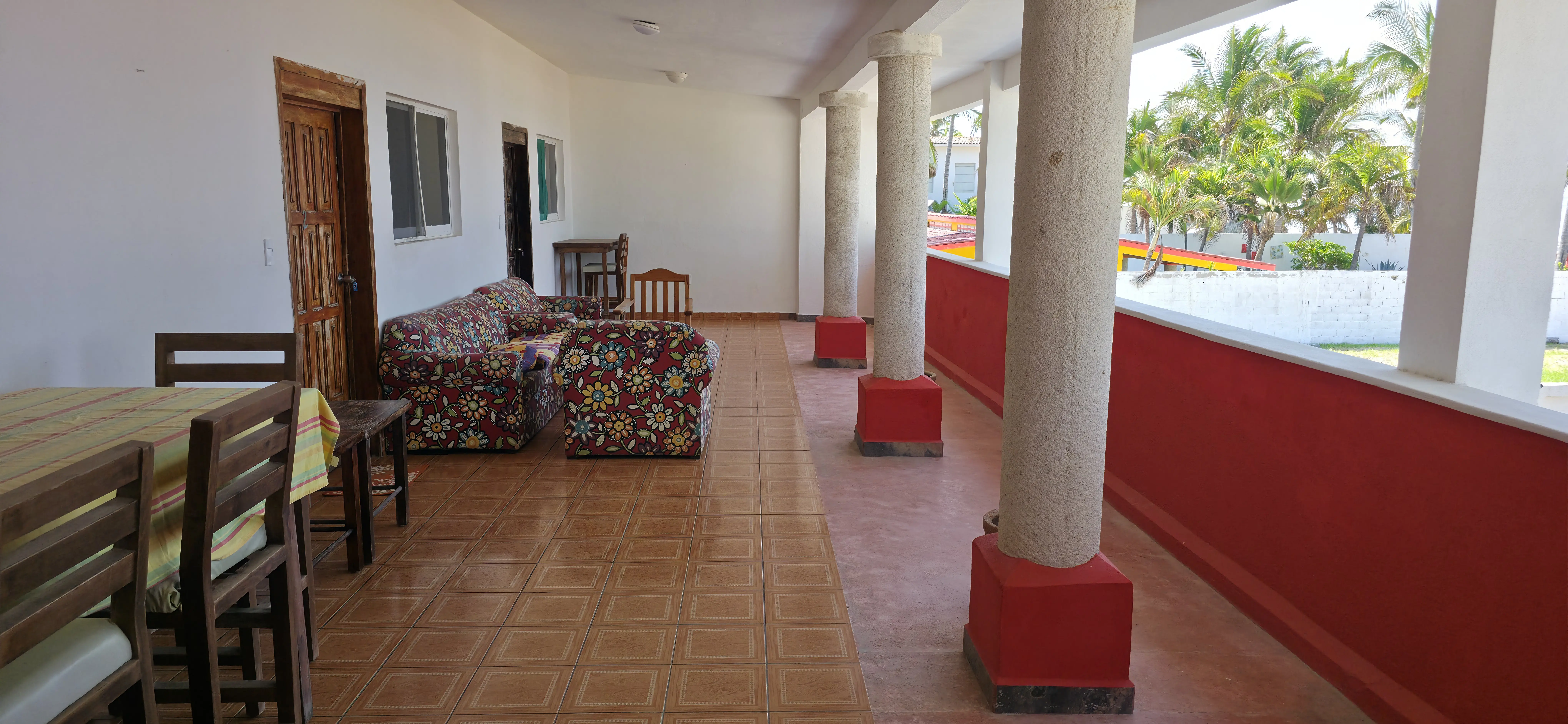 Terraza con columnas rojas que se abre hacia el océano